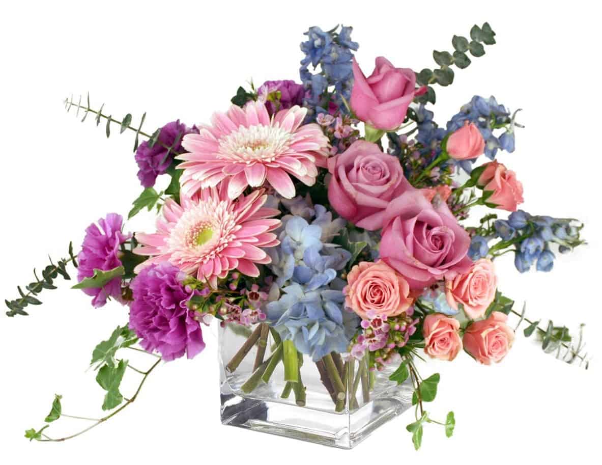 Romantic pastel colors are beautifully arranged in a square glass container. Overflowing with gerbera daisies, roses, hydrangea and more, this is the perfect gift to show off your long-lasting love.