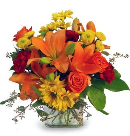 This bright and cheerful arrangement promises sunny days are ahead! Designed in a glass square vase orange lilies dance with roses and yellow daisies.