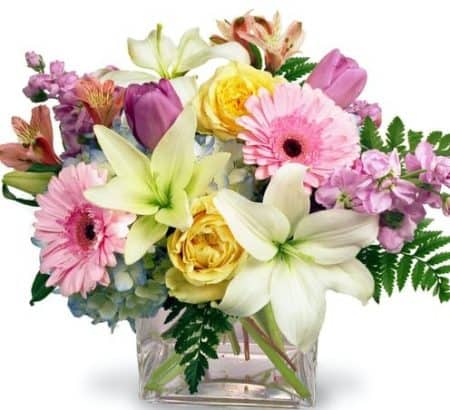 Make the day special by sending this gorgeous mix of pastel-colored flowers put together in a glass cylinder vase.